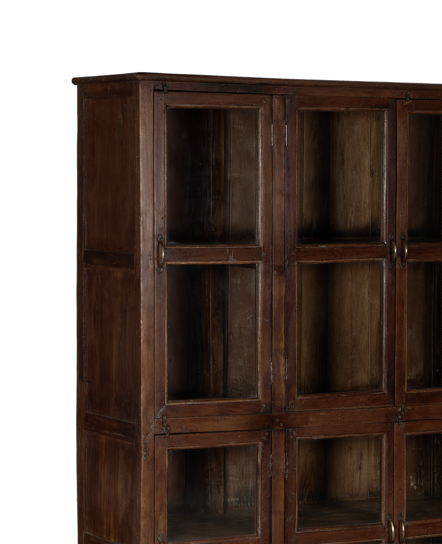 Vintage Indian oak wood cabinet, close-up of glass doors and aged brass handles.