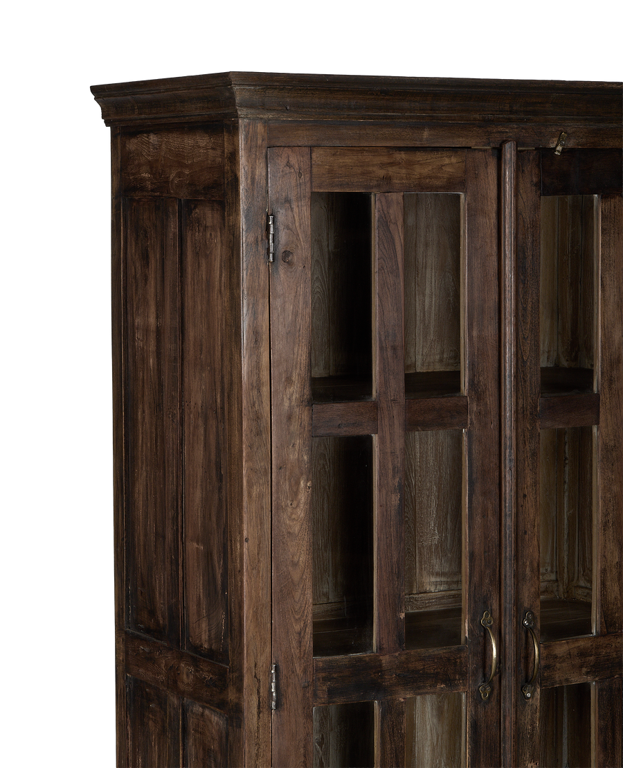 Close-up of vintage Indian oak wood cabinet's natural grain and glass doors.