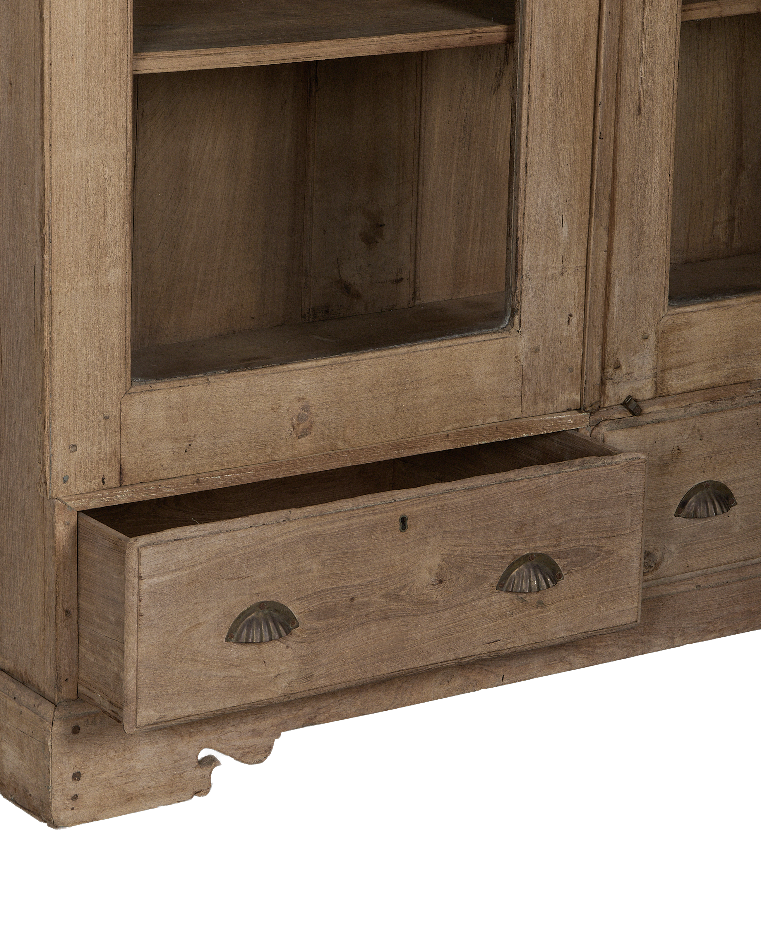 Open bottom drawer on vintage natural oak display cabinet from India, showing worn wood.