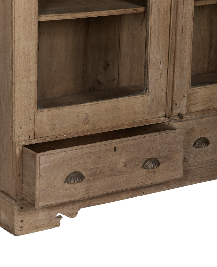 Open bottom drawer on vintage natural oak display cabinet from India, showing worn wood.