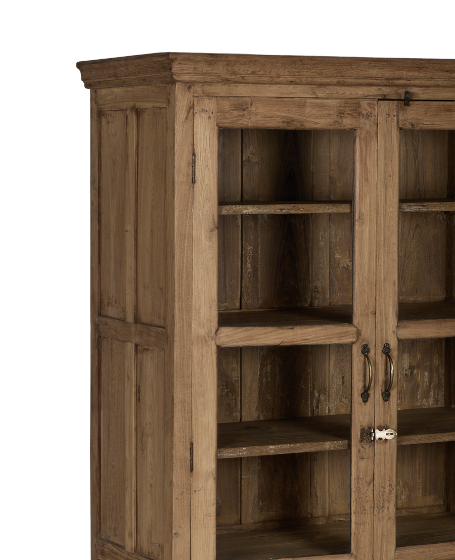 Vintage Indian oak cabinet featuring glass doors, ornate metal handles, and visible wood grain.
