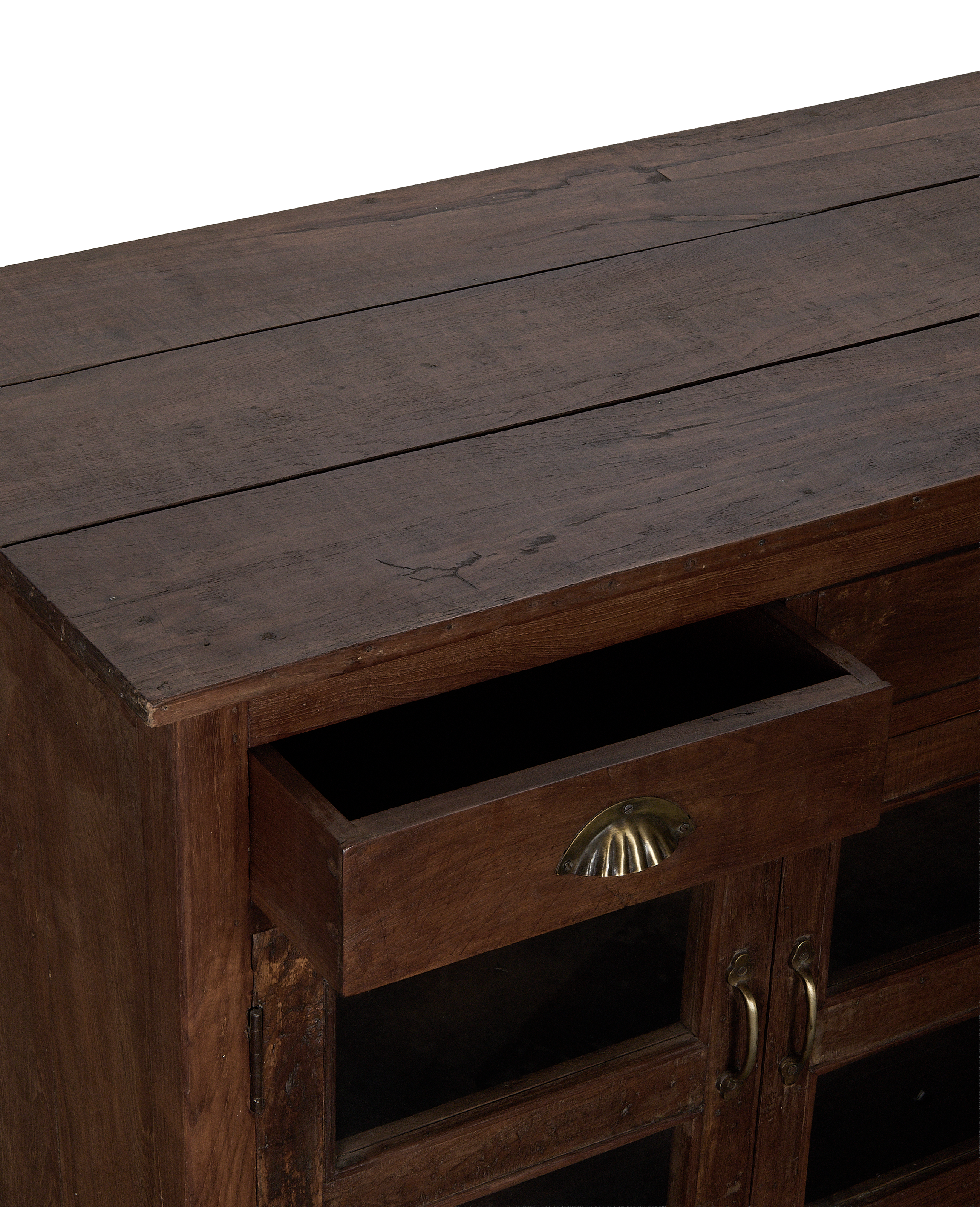 Open drawer of vintage oak sideboard from India, showing brass cup pull handle.