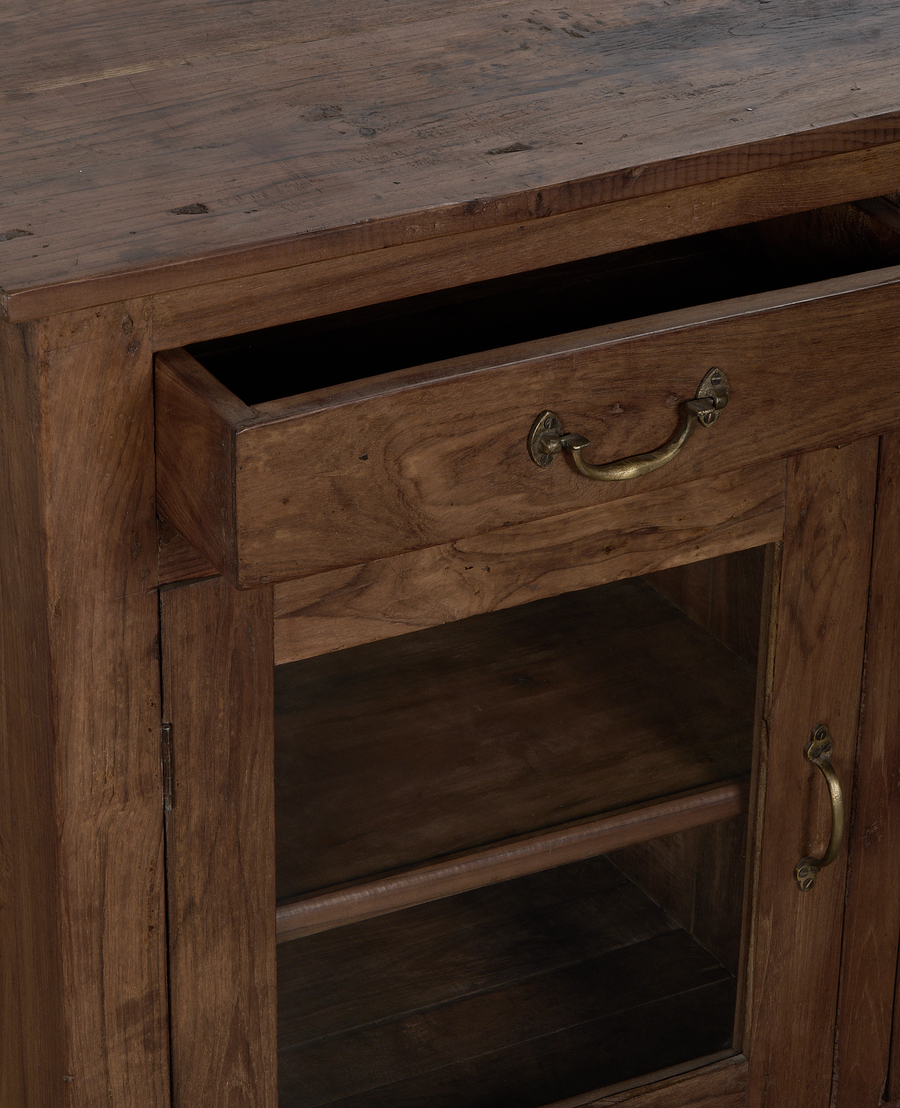 Open wooden drawer and brass handle details of vintage oak sideboard from India.