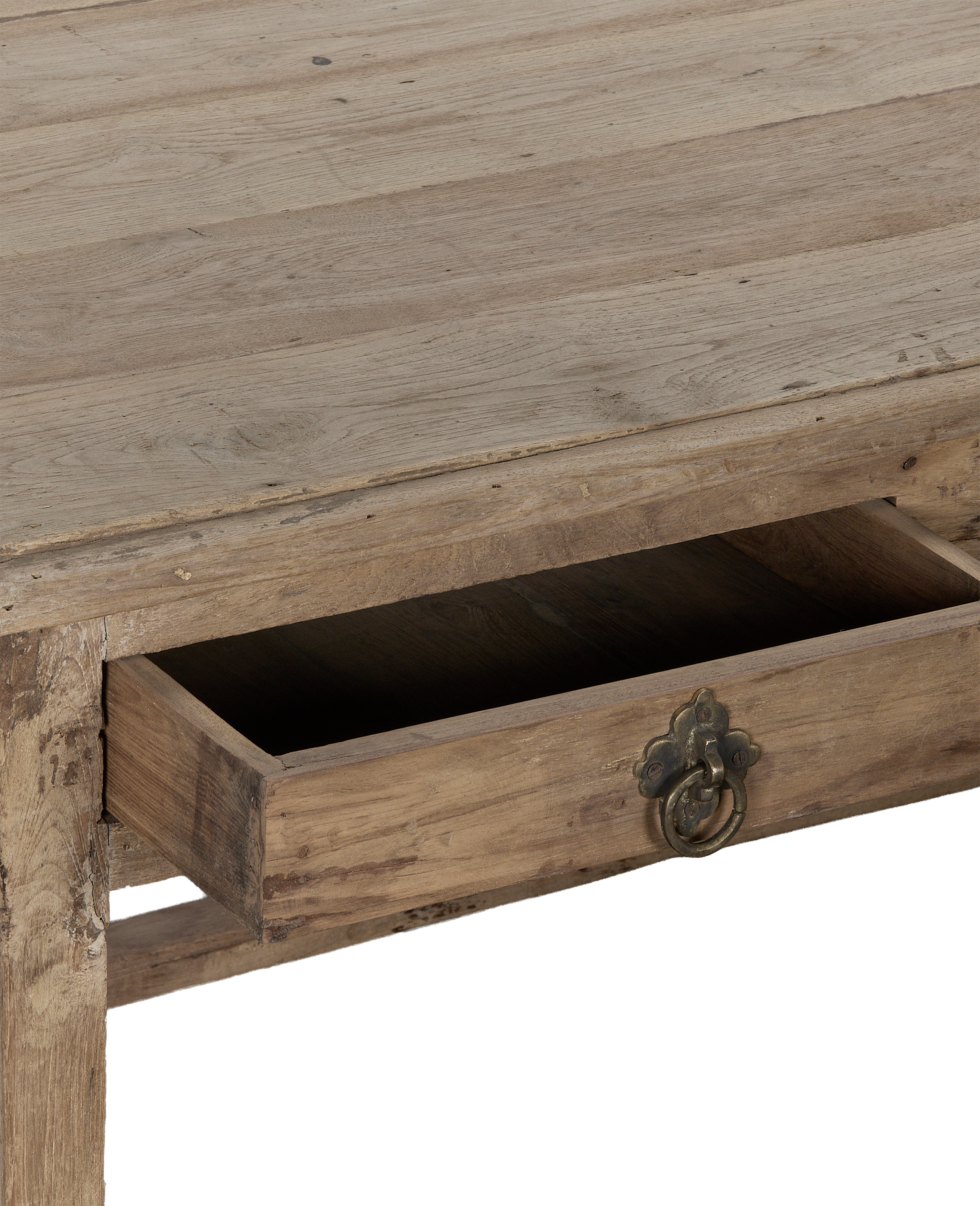 Open drawer of vintage bleached oak desk with ornate brass pull from India.