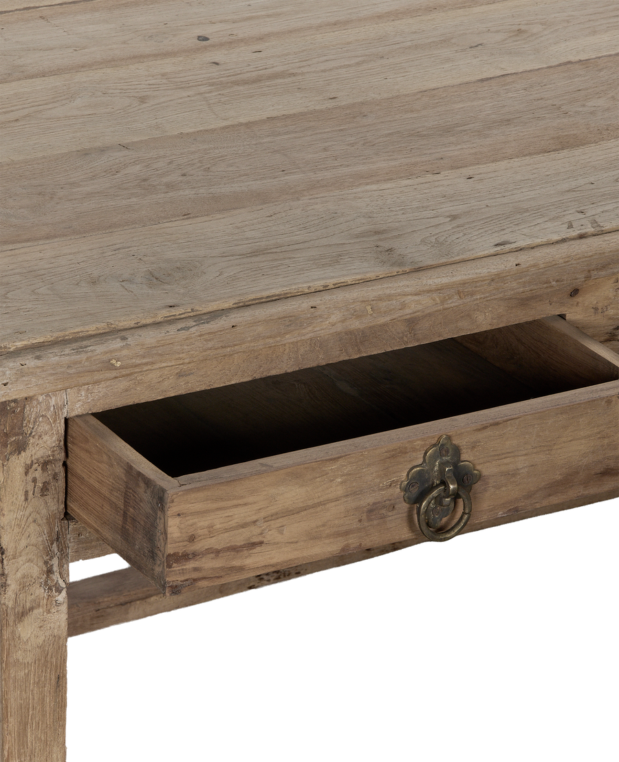 Open drawer of vintage bleached oak desk with ornate brass pull from India.