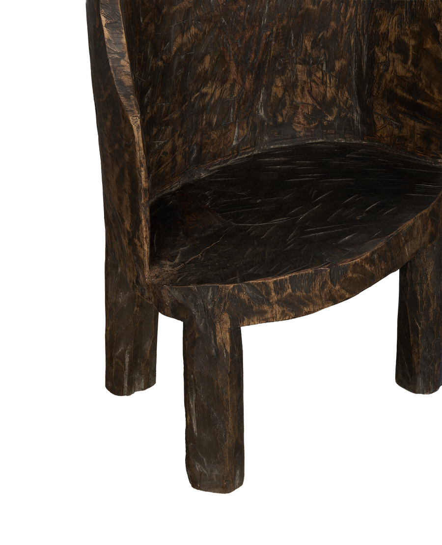 Vintage Nagaland oak chair's curved seat and sturdy carved legs, showing grain.
