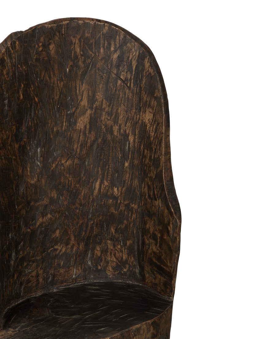 Close-up of vintage Nagaland oak chair's aged wood backrest texture.