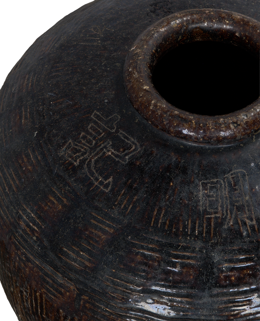 Vintage Chinese Willow Jar, close-up of dark brown ceramic with etched characters.
