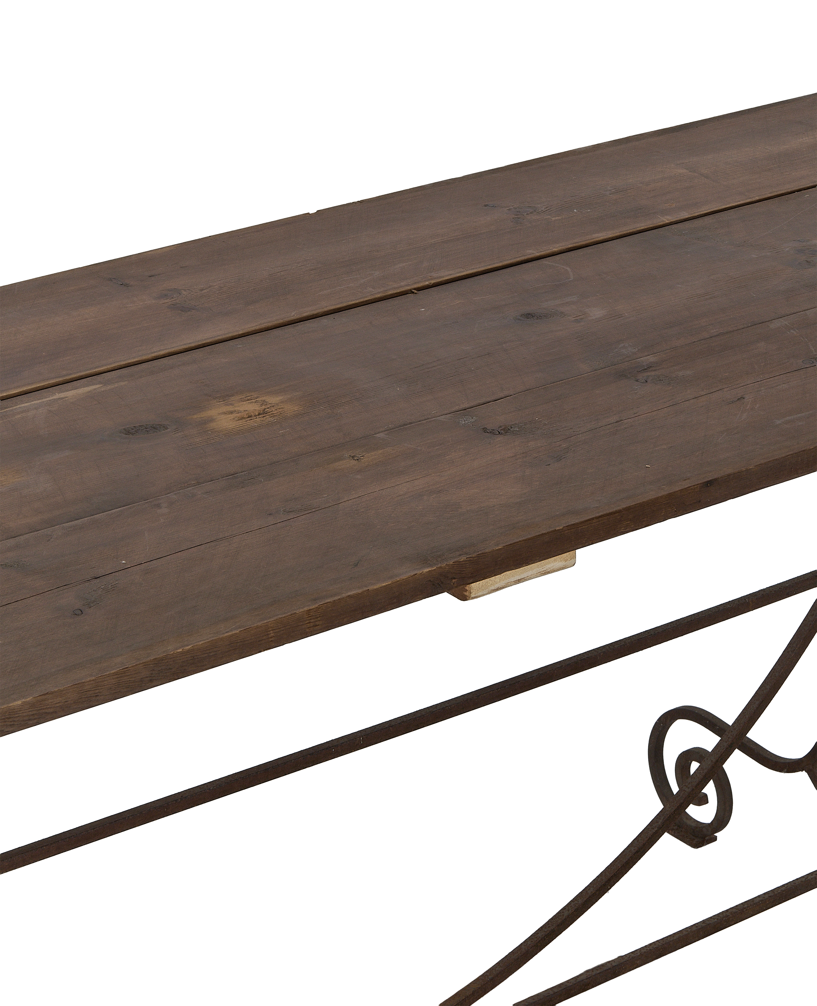 Close-up angle of weathered vintage oak tabletop planks and ornate wrought iron frame.