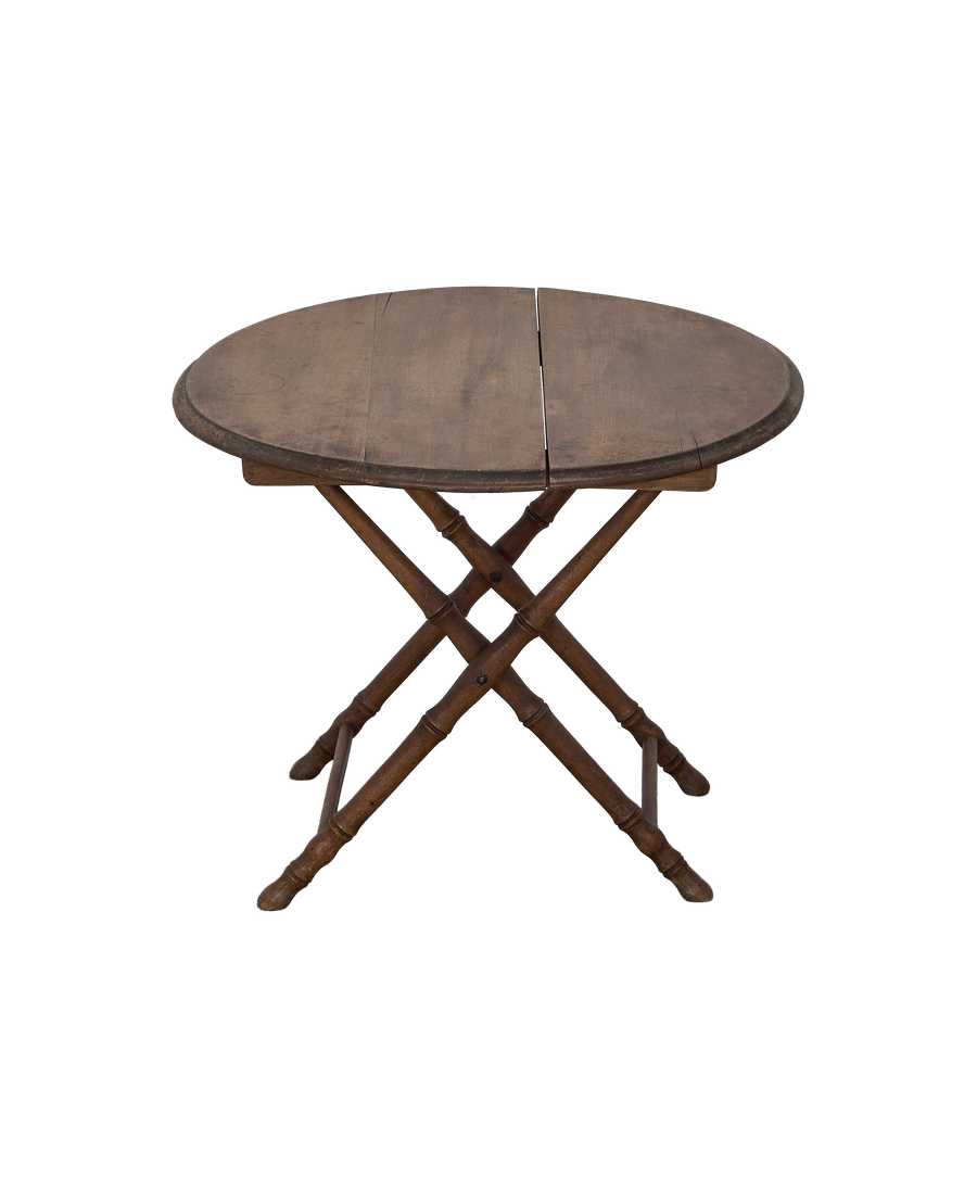 Vintage French bamboo folding table, closed, showing oak grain and folding leg mechanism.