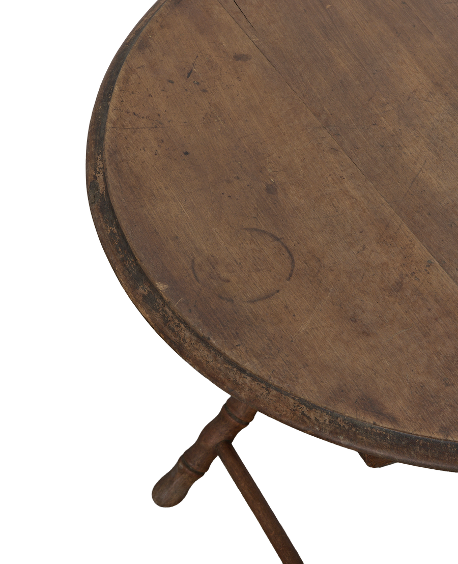 Vintage French oak folding table close-up, showing distressed round top, unique wood grain.