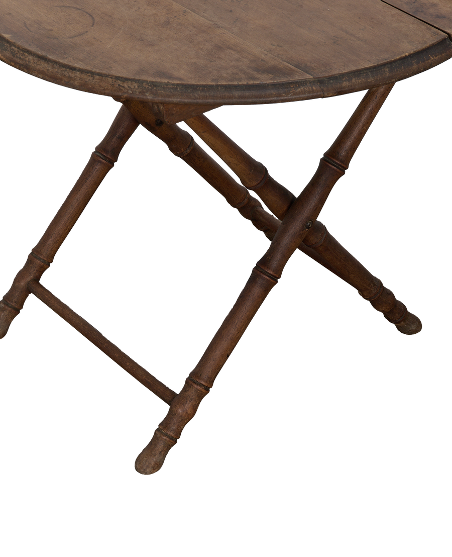Close-up of vintage French oak folding table legs with bamboo-style turning.