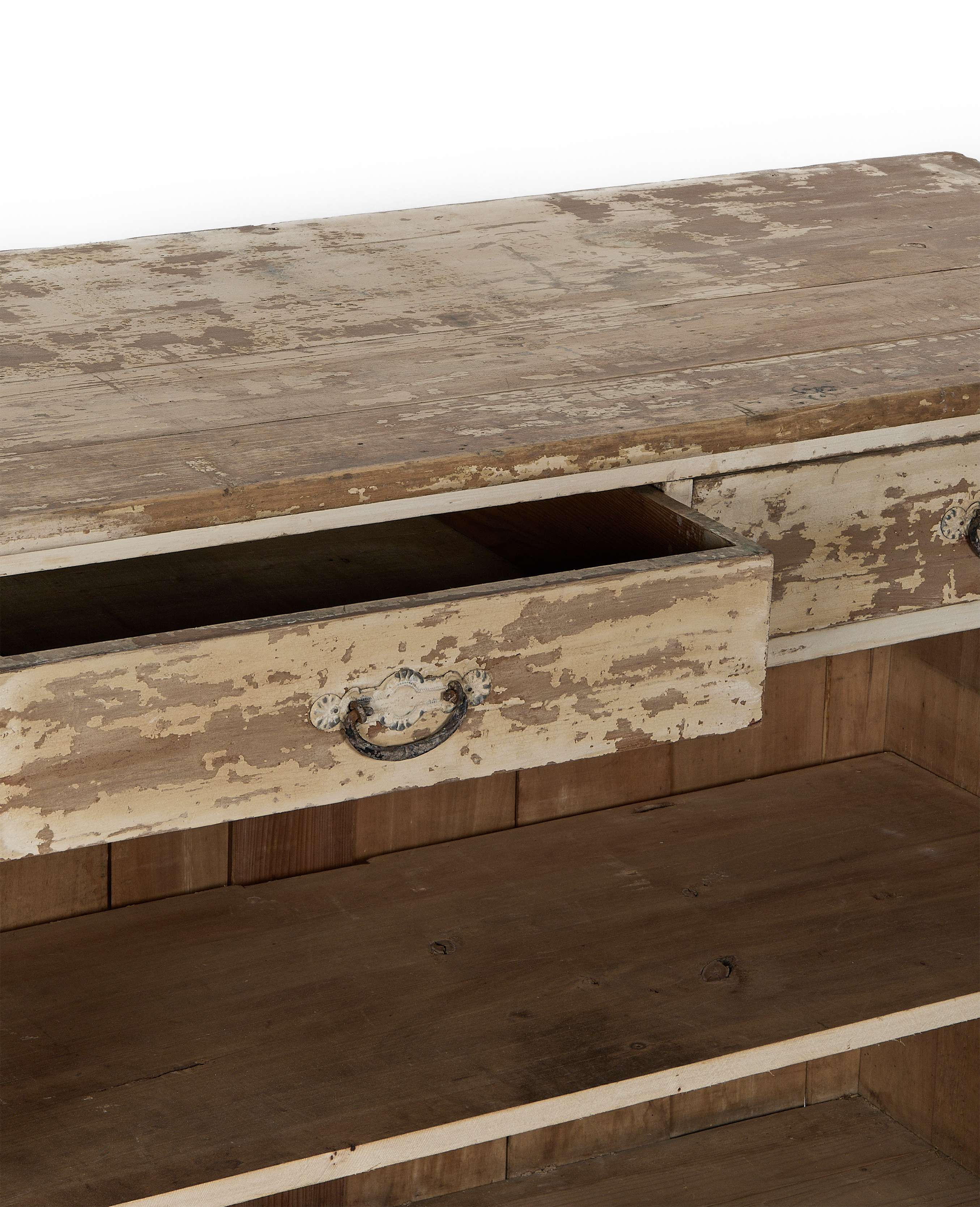 Open vintage French oak cabinet drawer, distressed white paint, showing decorative metal pull detail.