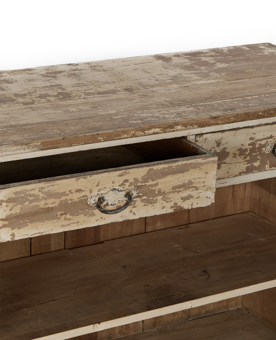 Open vintage French oak cabinet drawer, distressed white paint, showing decorative metal pull detail.
