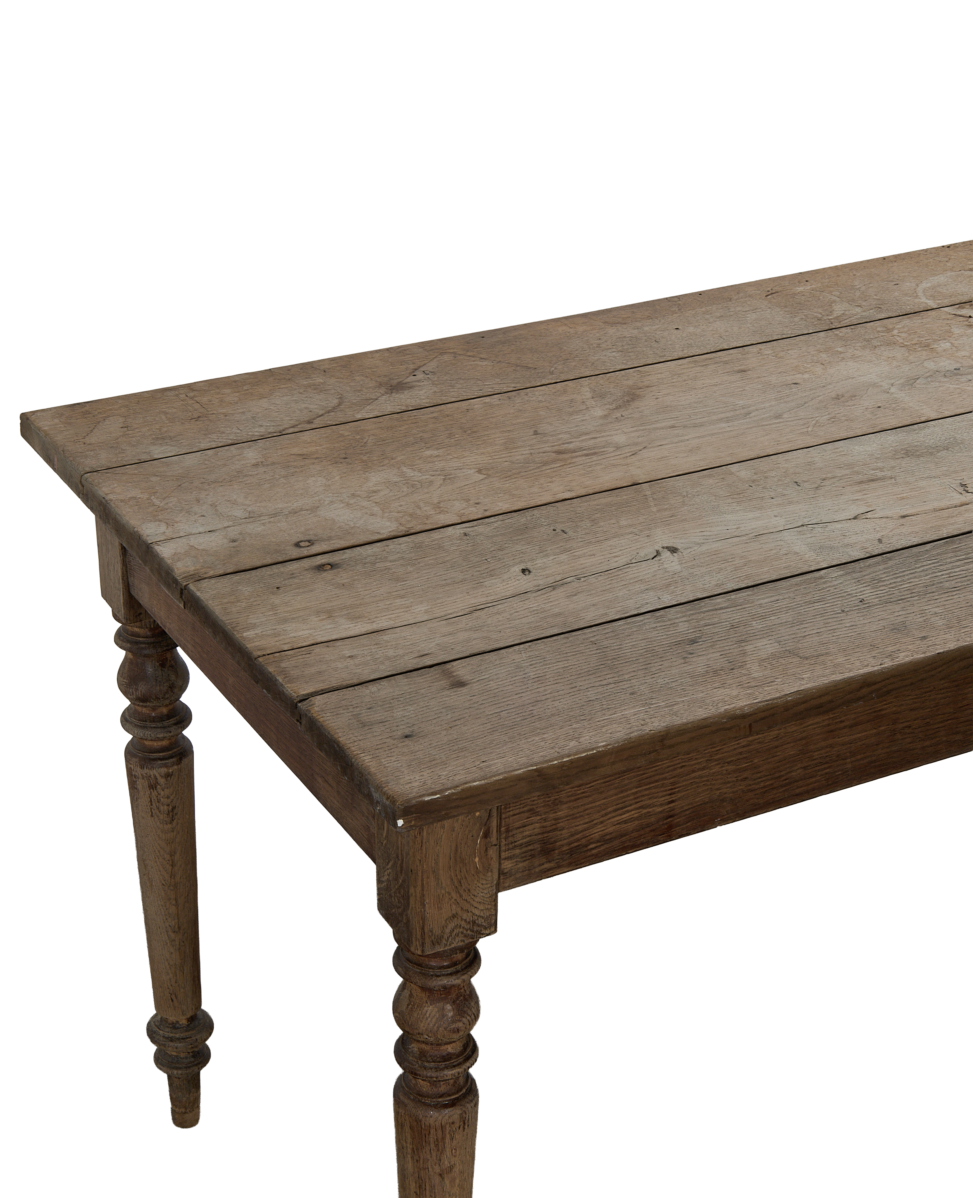 Vintage French oak farm table, distressed planks and turned legs, close-up corner view.