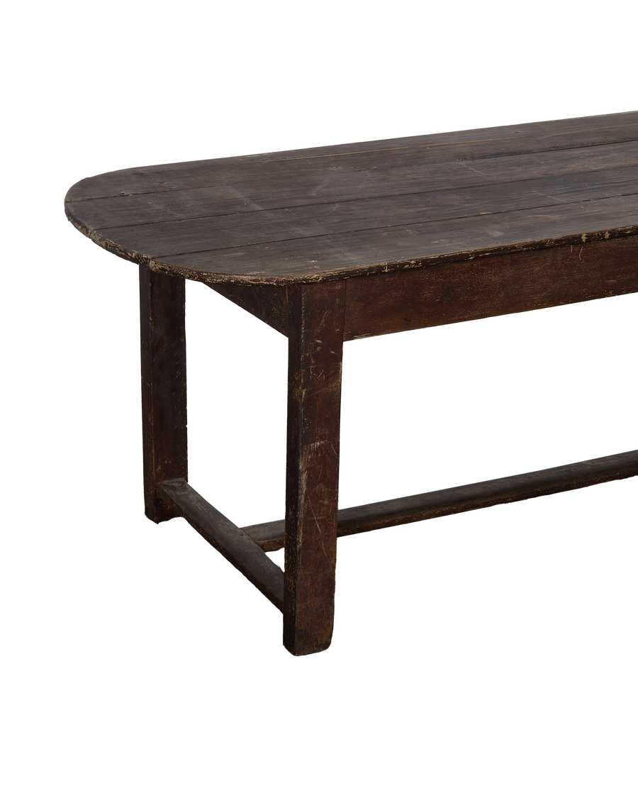 Vintage French oval oak table showing weathered wood top and distressed leg detail.