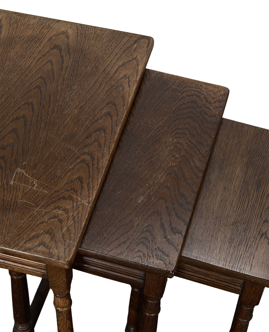 Vintage French oak nesting tables, showing individual tops, grain, and general antique wear.