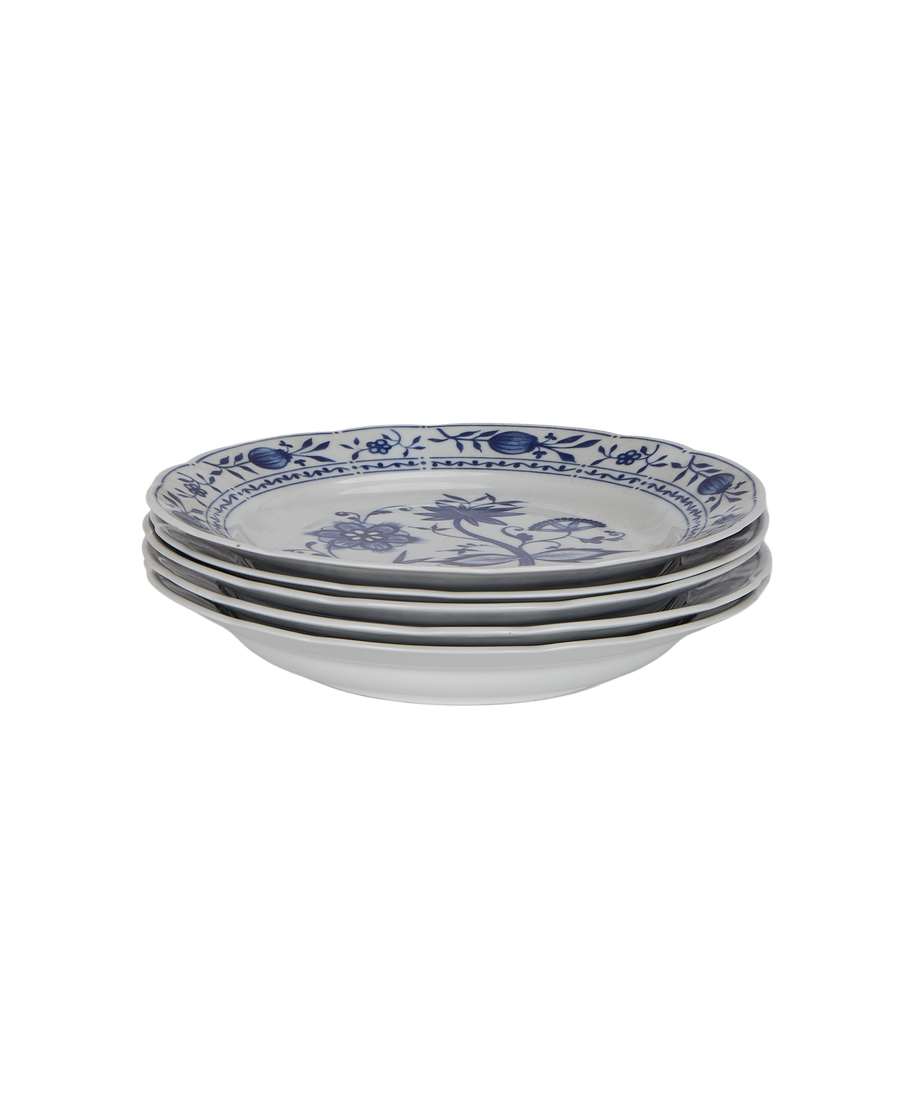 Stack of four vintage French blue floral porcelain plates, showing depth.