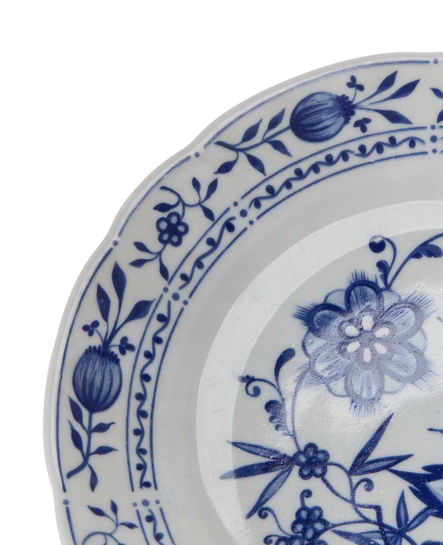 Close-up of vintage French blue and white floral china dishware rim details.