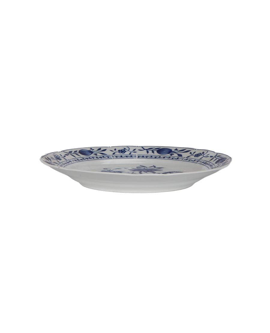 Vintage French porcelain plate side view, blue floral border, showing raised rim detail.