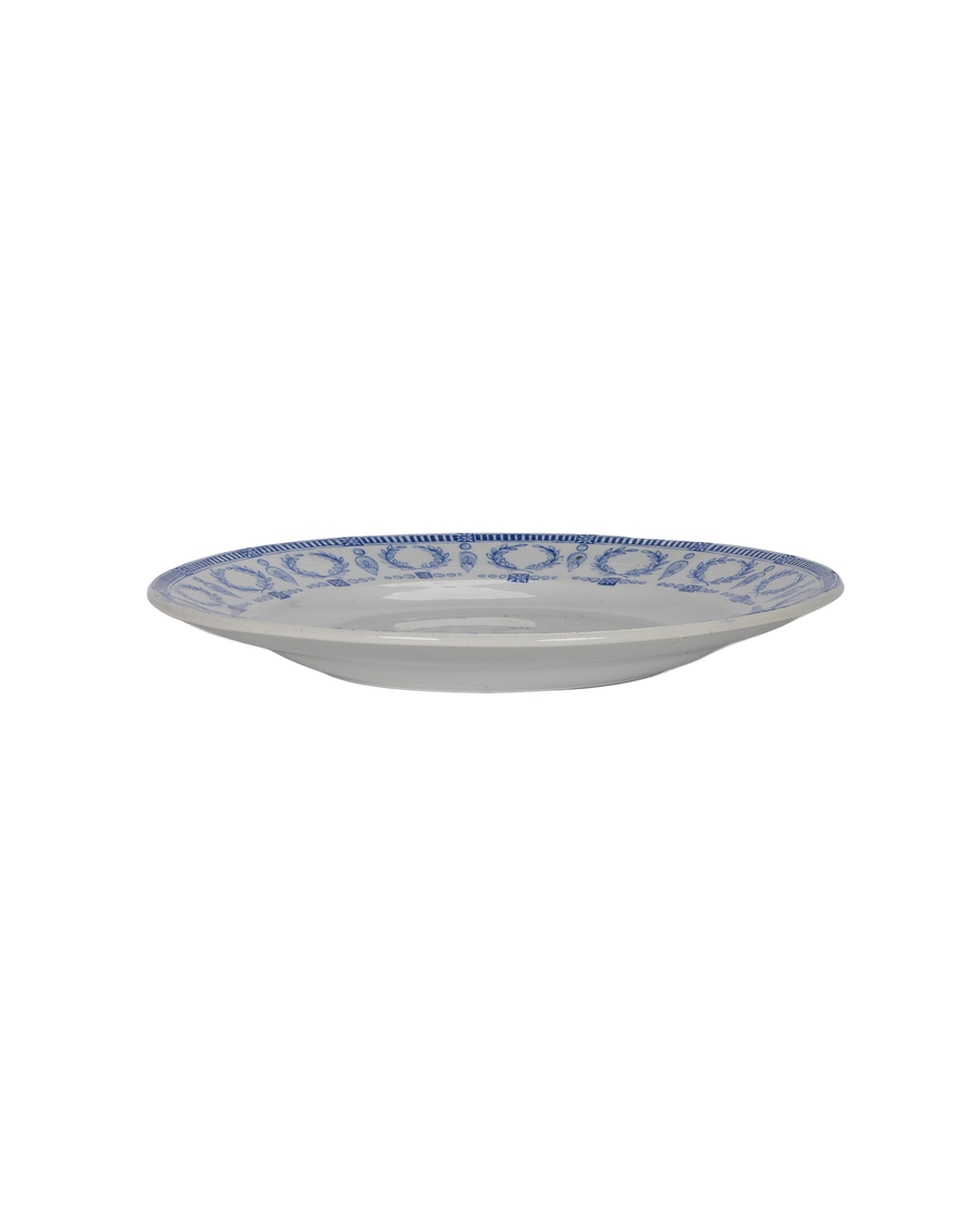 Vintage French blue and white plate, side view displaying decorative rim pattern.
