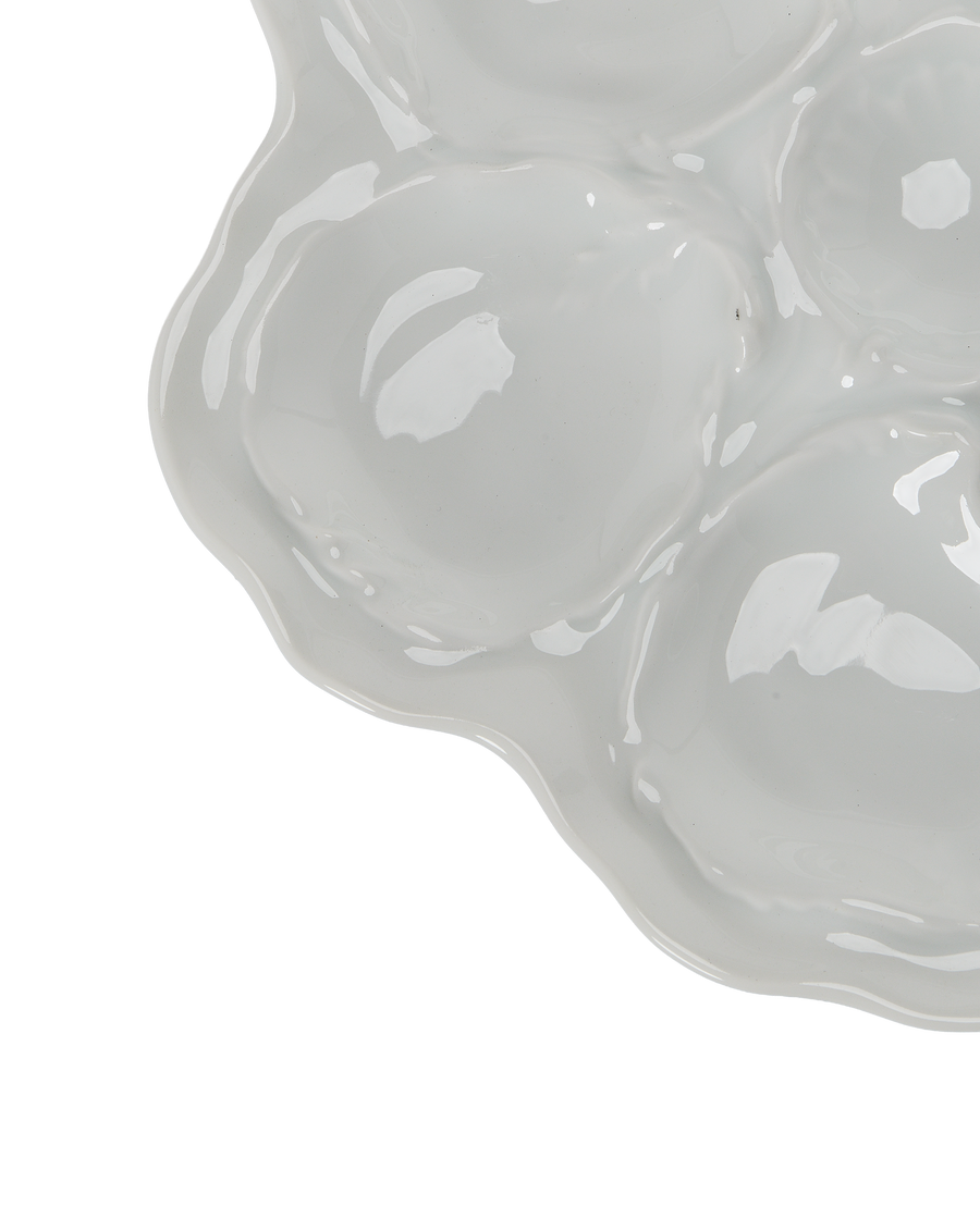 Close-up of vintage Limoges oyster plate, showing textured wells and wavy edge detail.