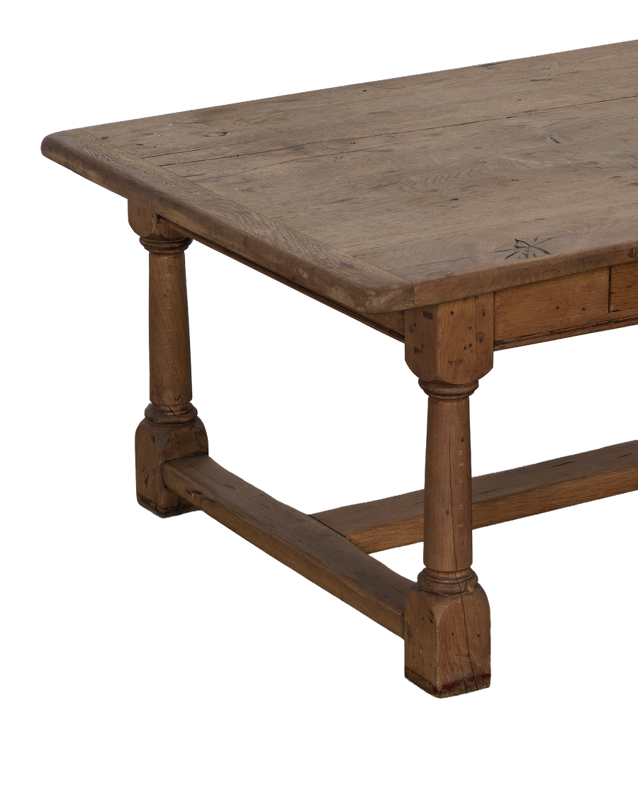 Vintage French oak Draper style coffee table showcasing turned legs and weathered tabletop texture.