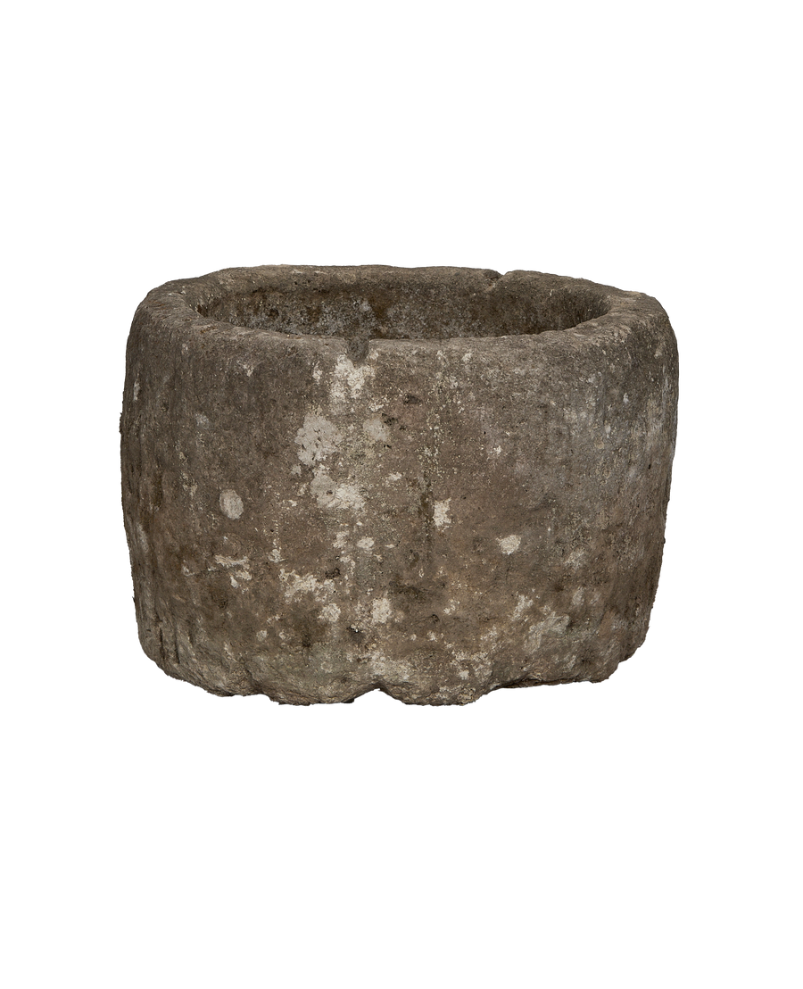 Vintage round Indonesian limestone trough showing weathered exterior texture and rugged edge detail.