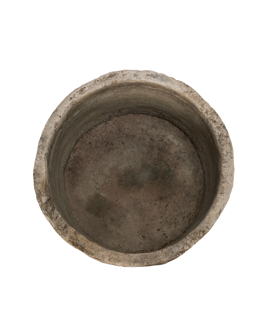 Vintage round limestone trough, top-down view showing weathered interior and