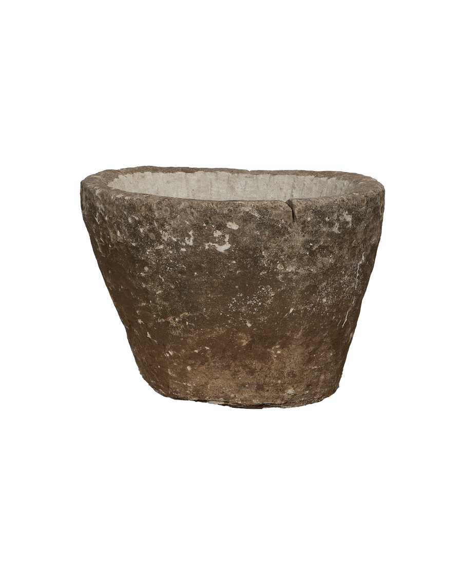 Vintage round limestone trough, side view revealing rustic texture and natural aged patina.
