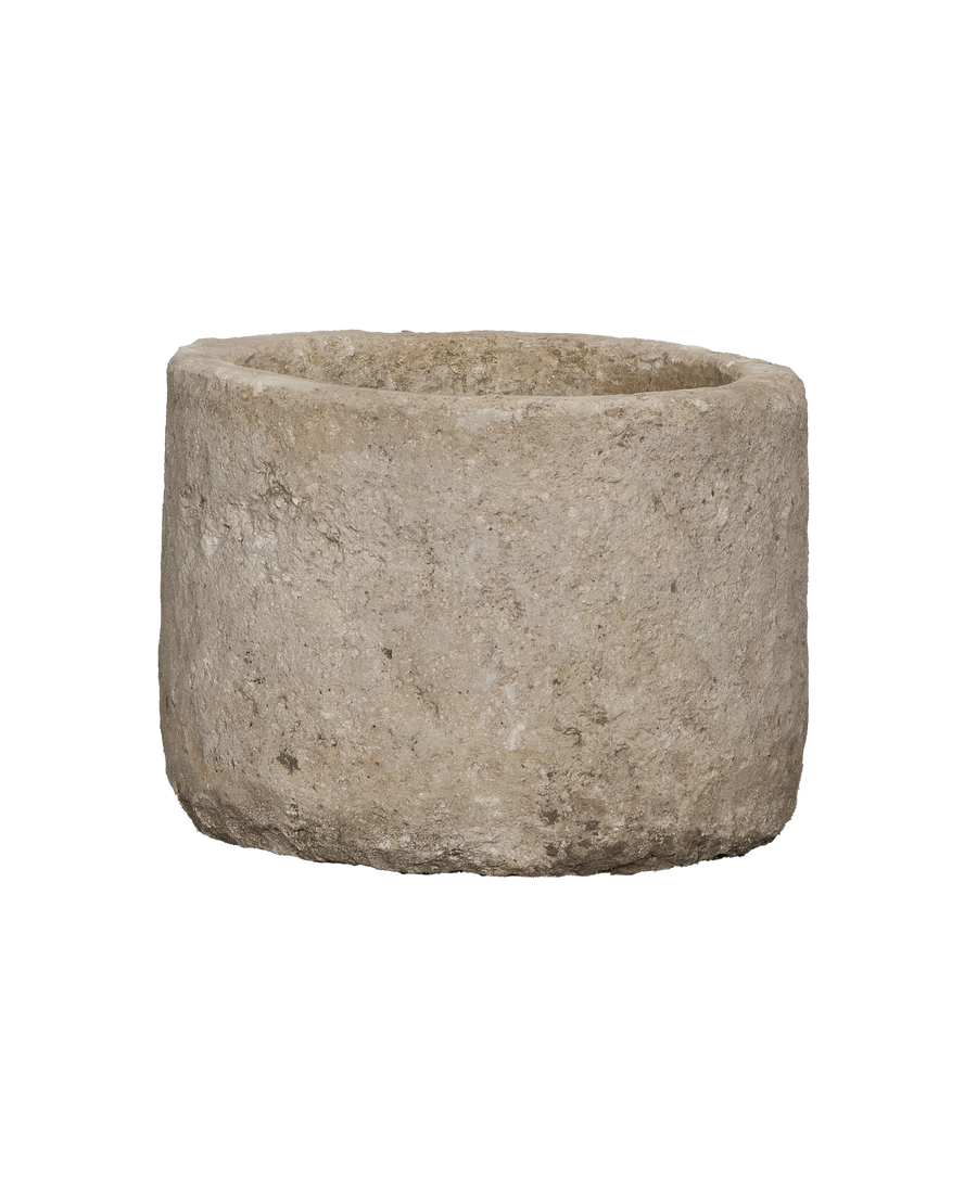 Vintage round limestone trough, close-up showing weathered texture and imperfections.