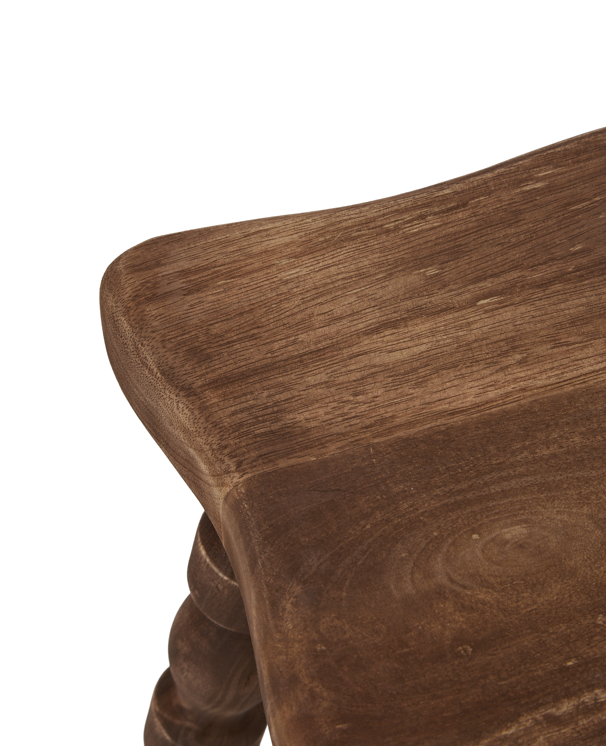 Close-up detail of the wooden leg structure of a milking stool.