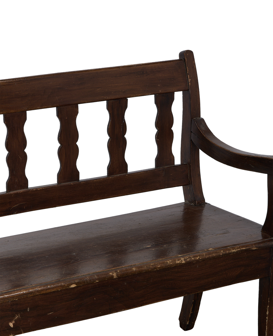 Vintage French oak sitting bench, closeup of distressed seat with scrolled armrest.