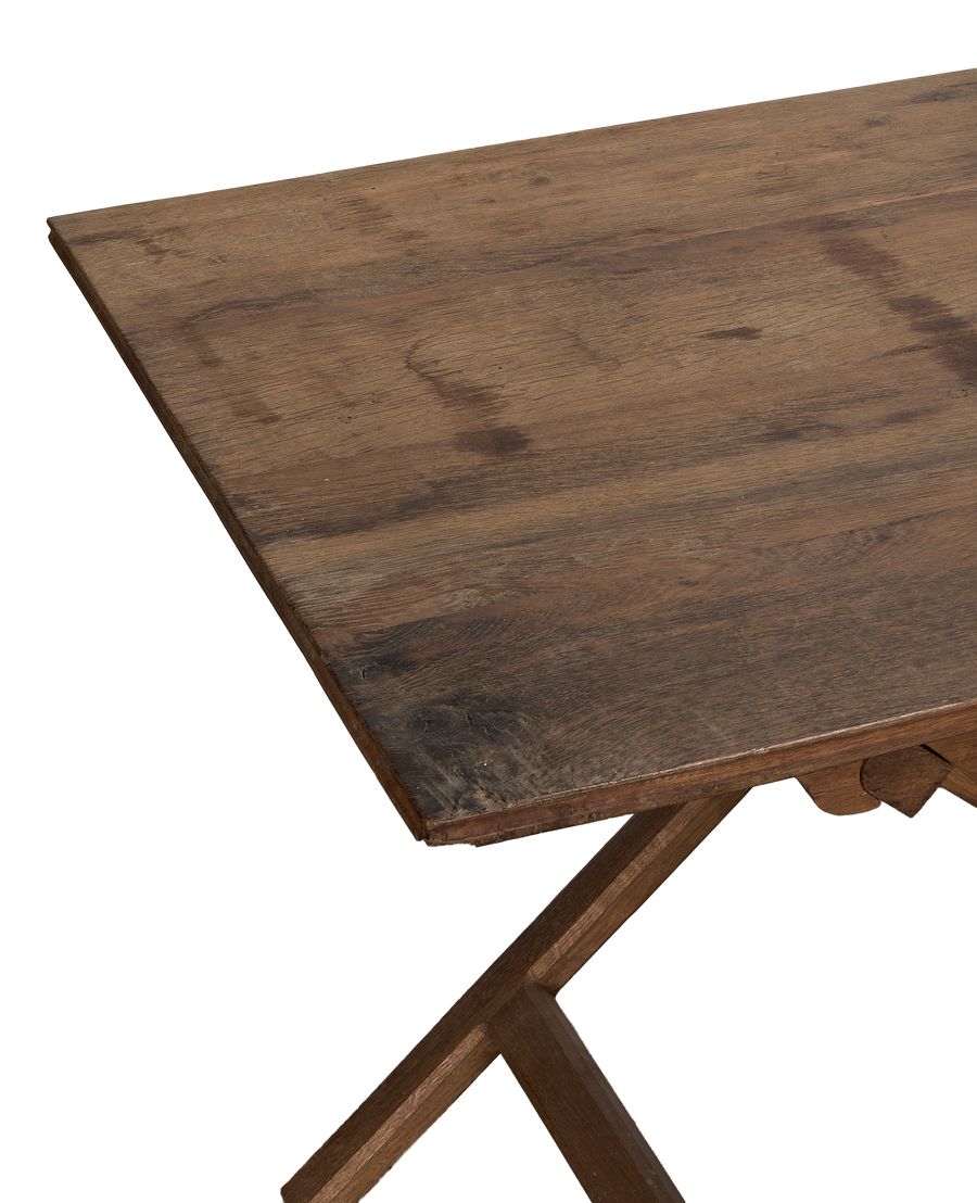 Vintage French oak wine table's weathered tabletop and rustic foldable base detail.