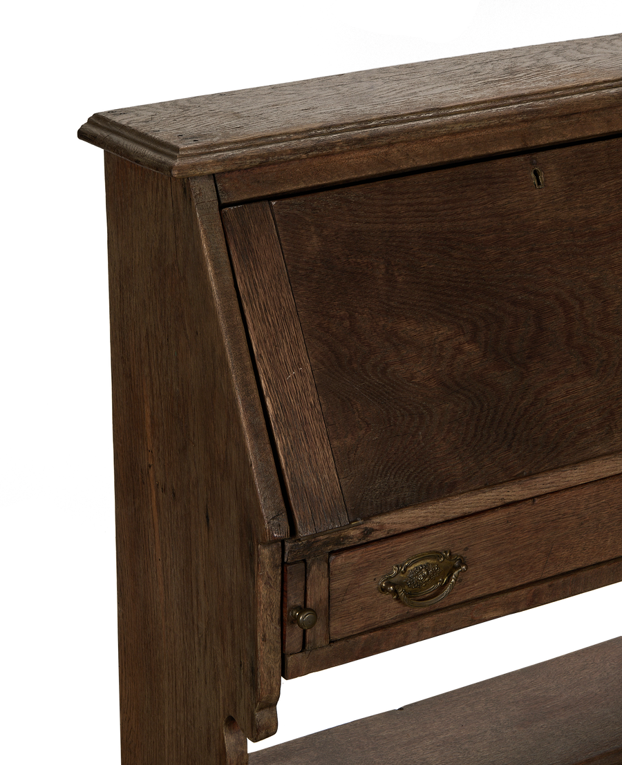 Vintage French oak secretary cabinet desk, showing intricate top molding and closed writing surface detail.