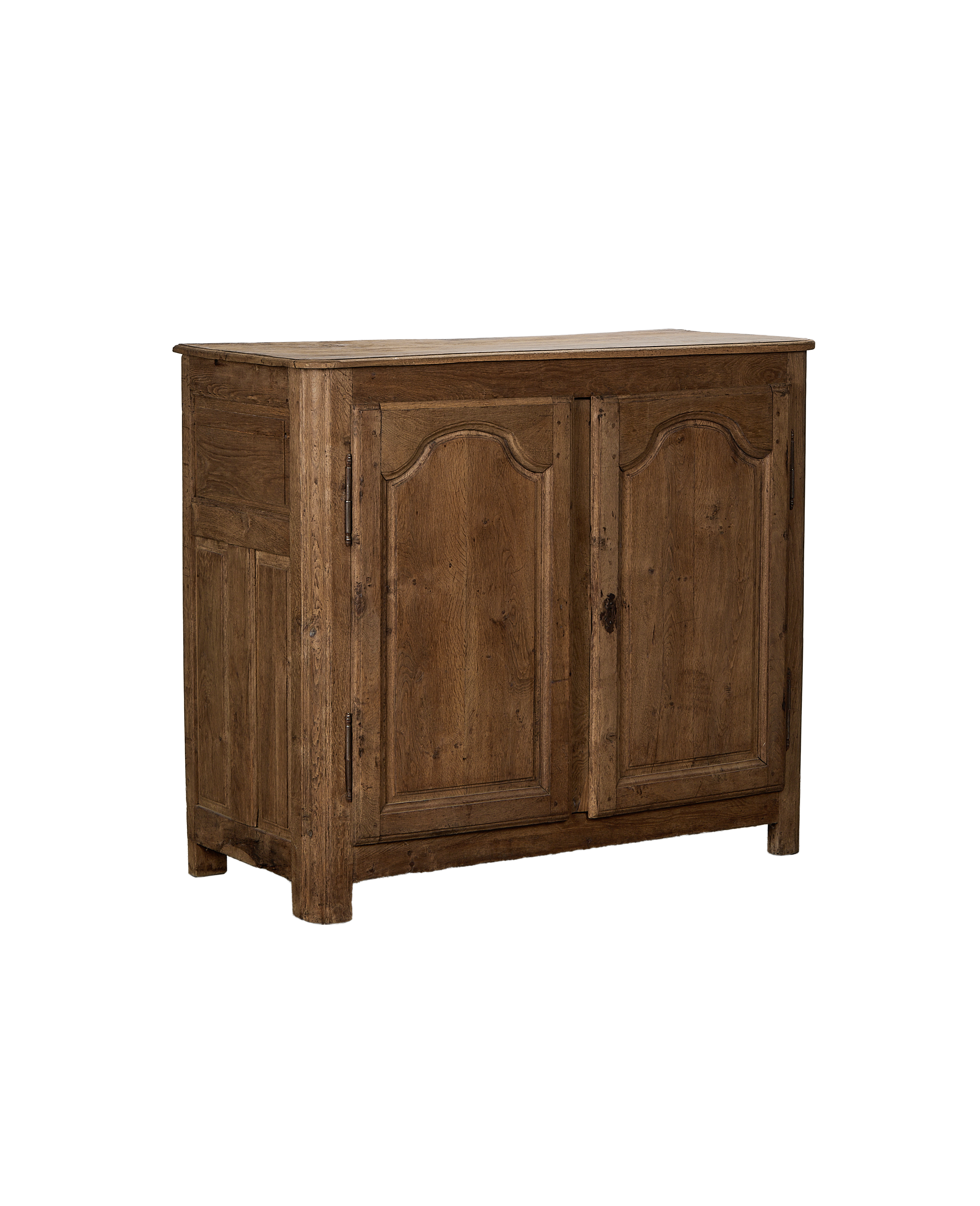 Vintage French oak sideboard angled view, showcasing rustic wood grain and ornate door carvings.