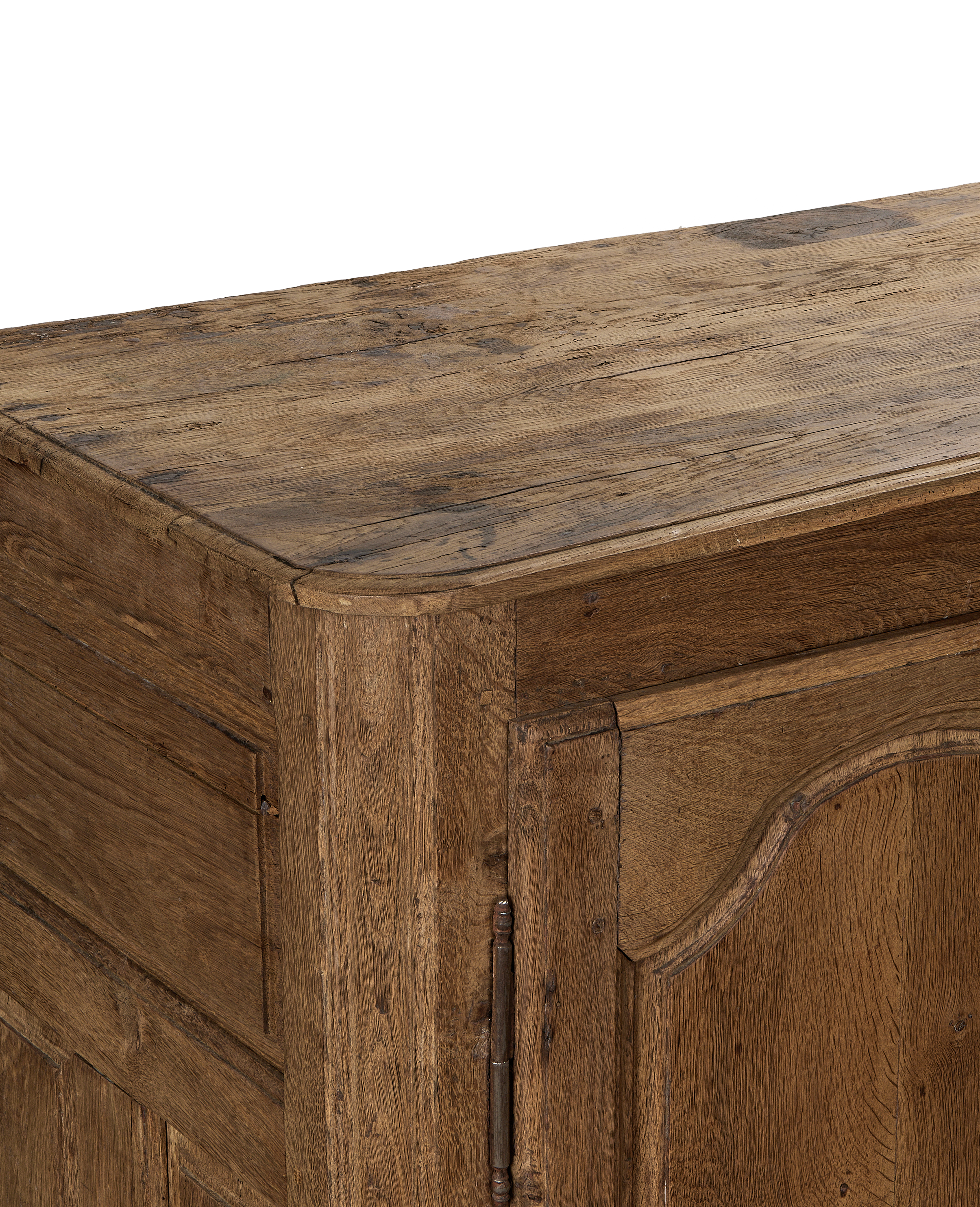 Close-up of vintage French oak sideboard's weathered wood top and carved cupboard door.