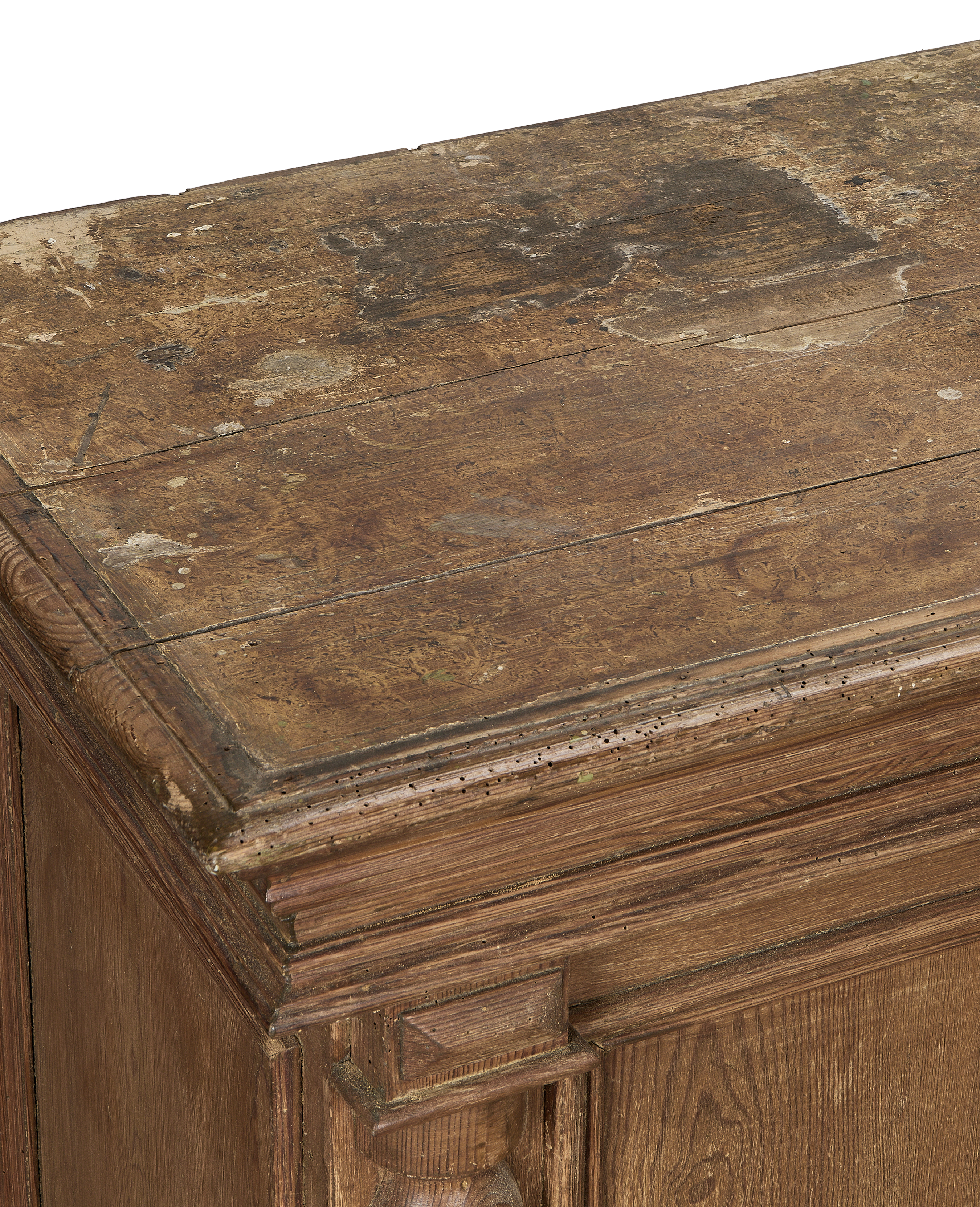 Vintage French oak shop counter's distressed, worm-eaten top surface and ornate carved corner detail.