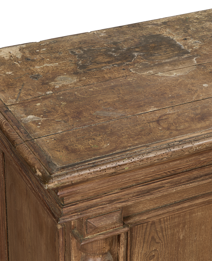 Vintage French oak shop counter's distressed, worm-eaten top surface and ornate carved corner detail.