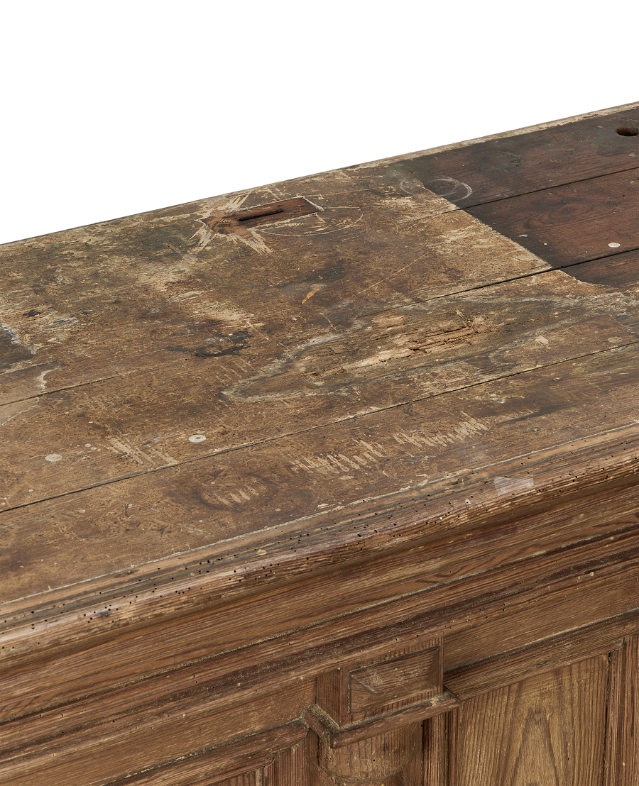 Distressed vintage oak shop counter top, showing wear, holes, and rich wood grain.
