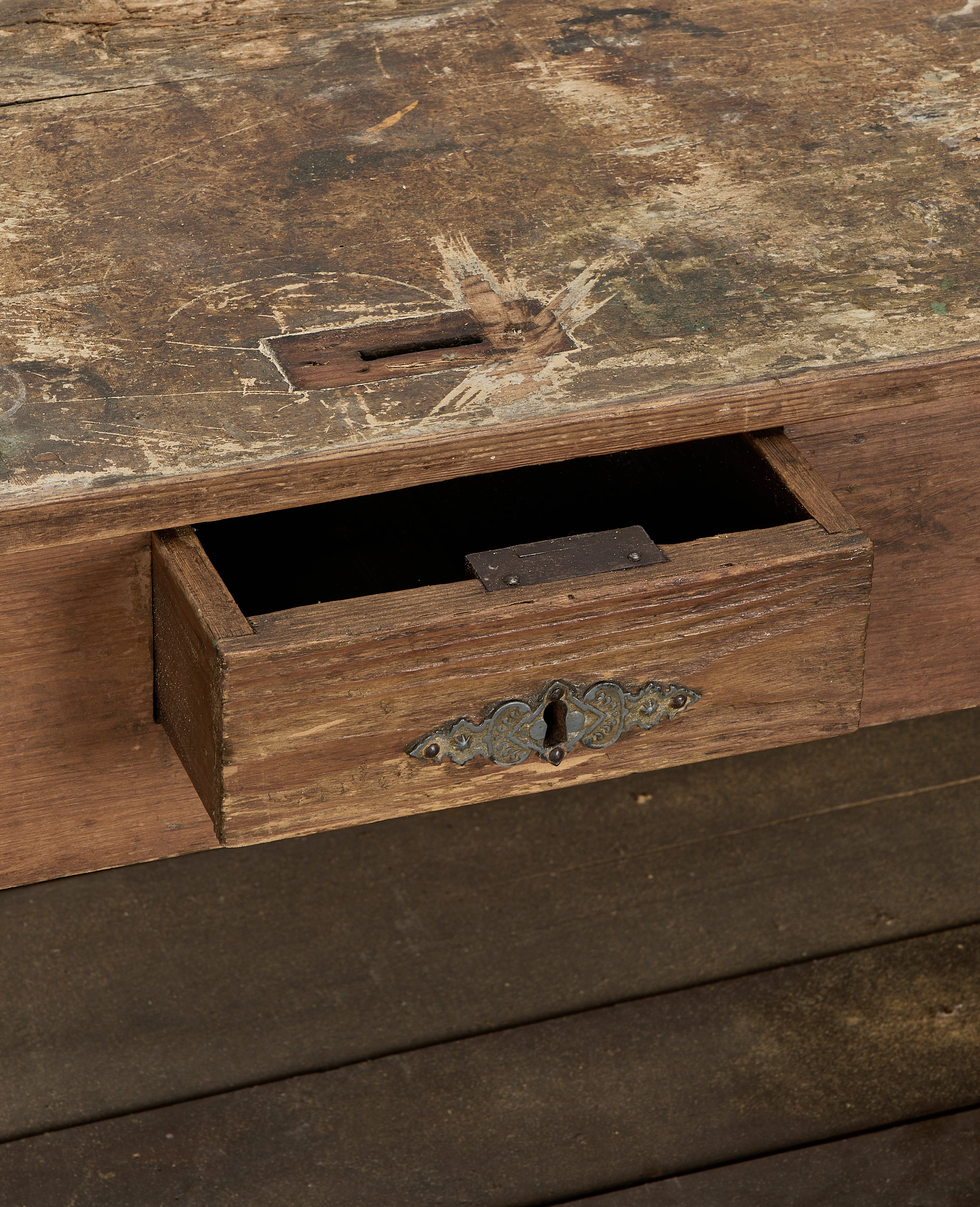 Closed-up open drawer of vintage French oak shop counter, aged surface details.
