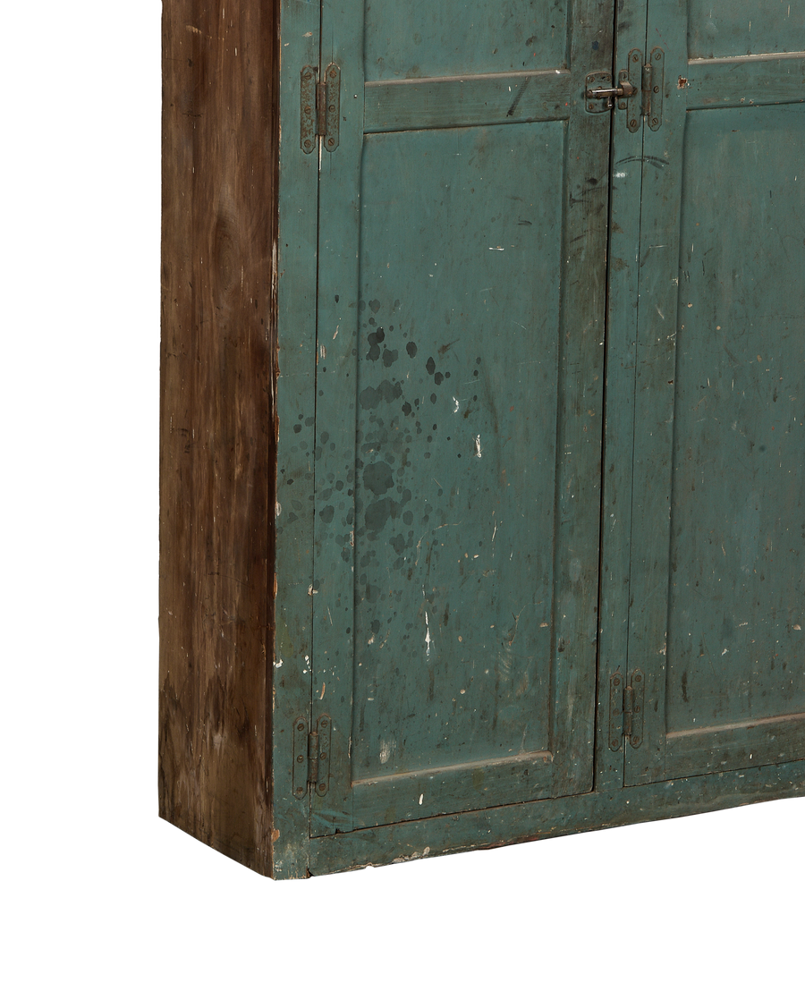 Close-up of vintage French oak locker's chipped teal paint and distressed wood side.