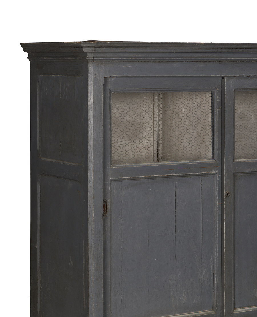 French vintage oak cabinet, painted gray, showing upper doors with chicken wire and distressed finish.