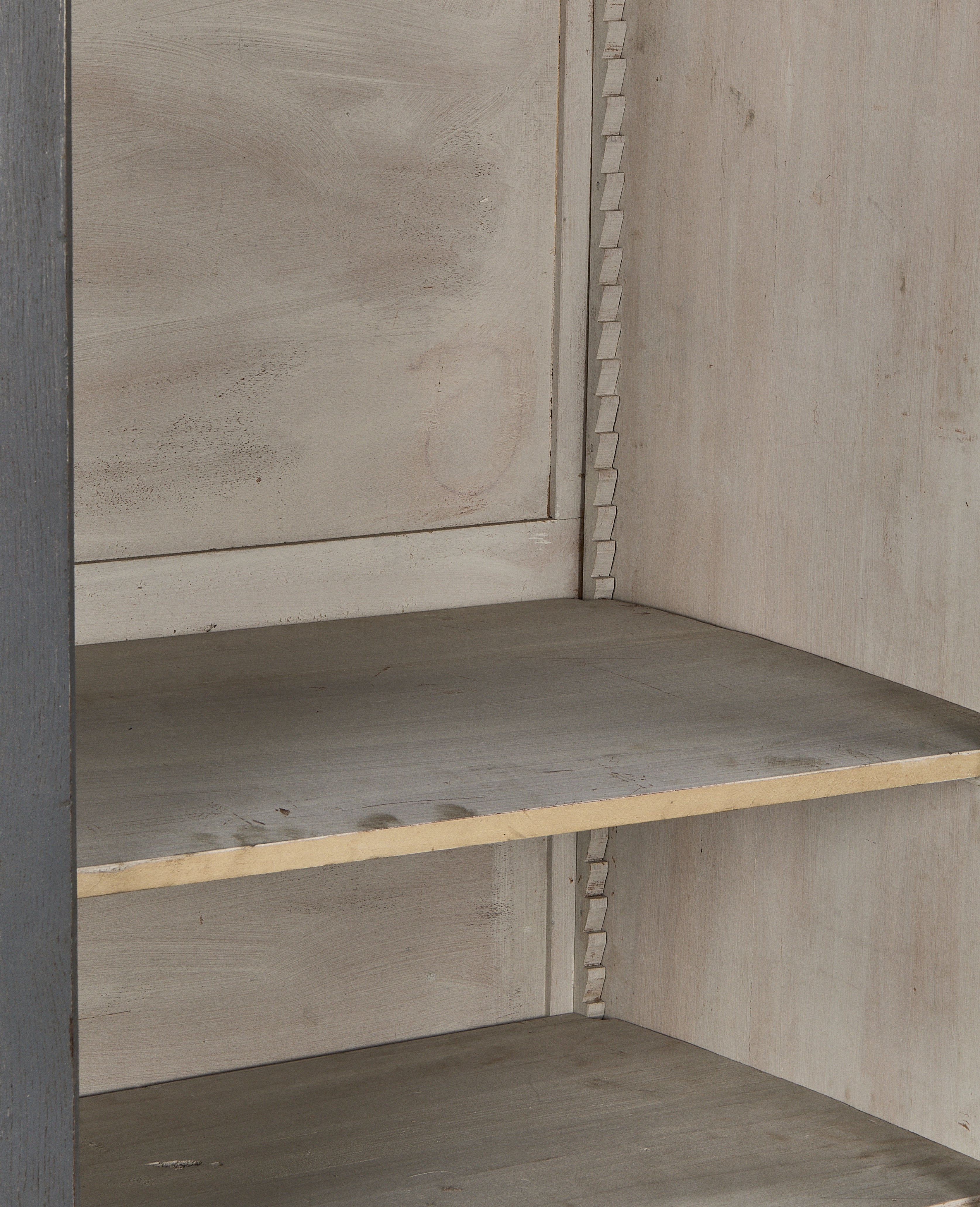 Vintage French oak cabinet interior with painted distressed finish and shelf peg details.