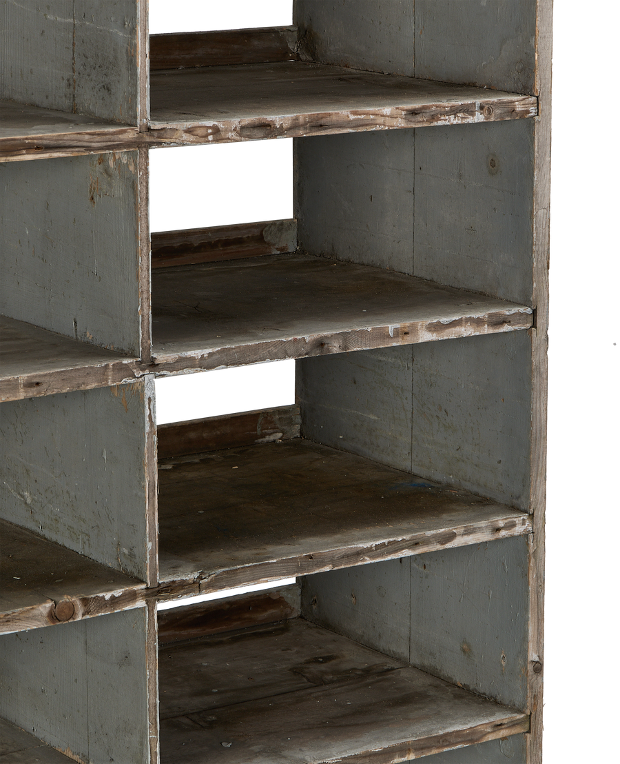 Close-up of vintage French oak shelves, showcasing worn green paint and rustic wood texture.