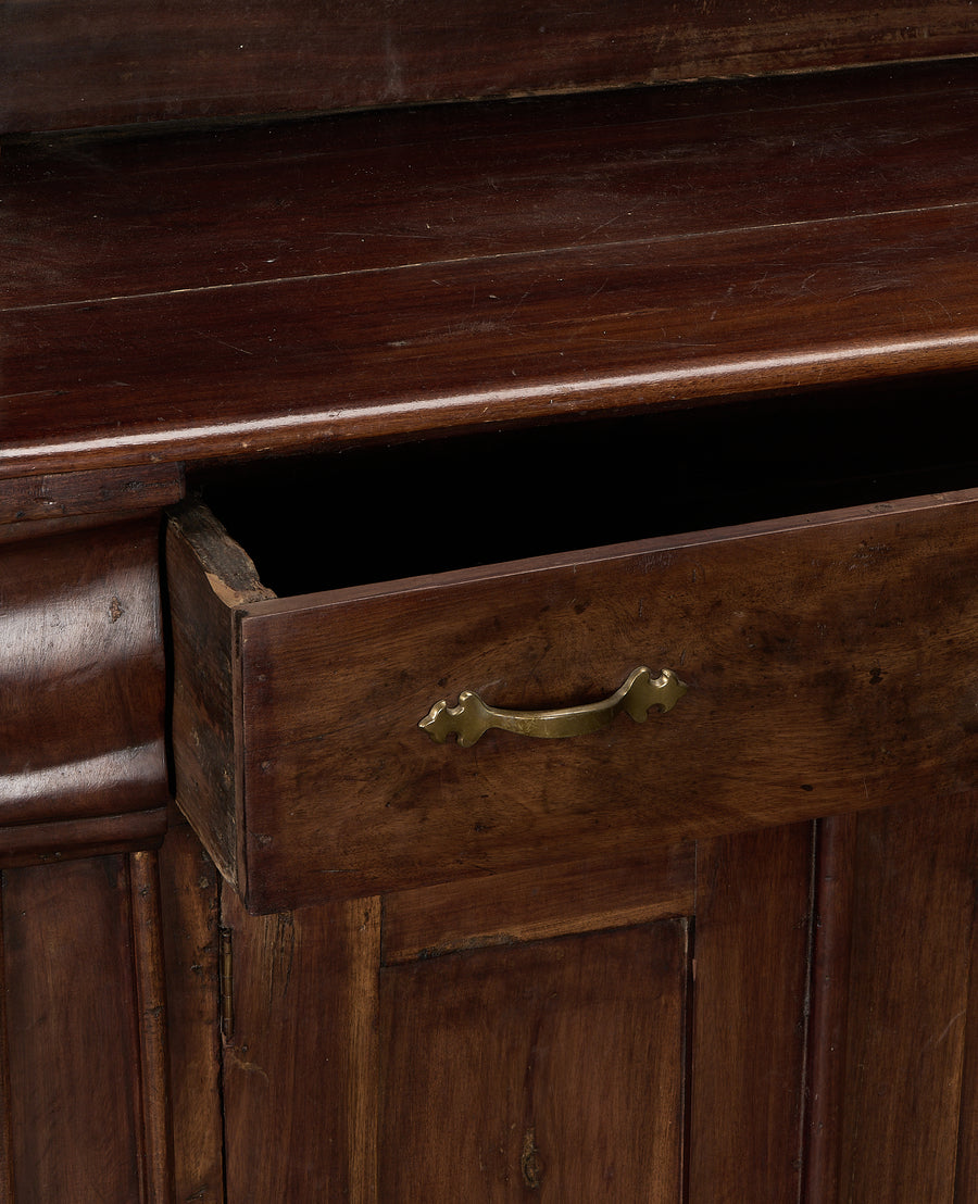 Open drawer of vintage French oak hutch, brass pull, dark wood interior.