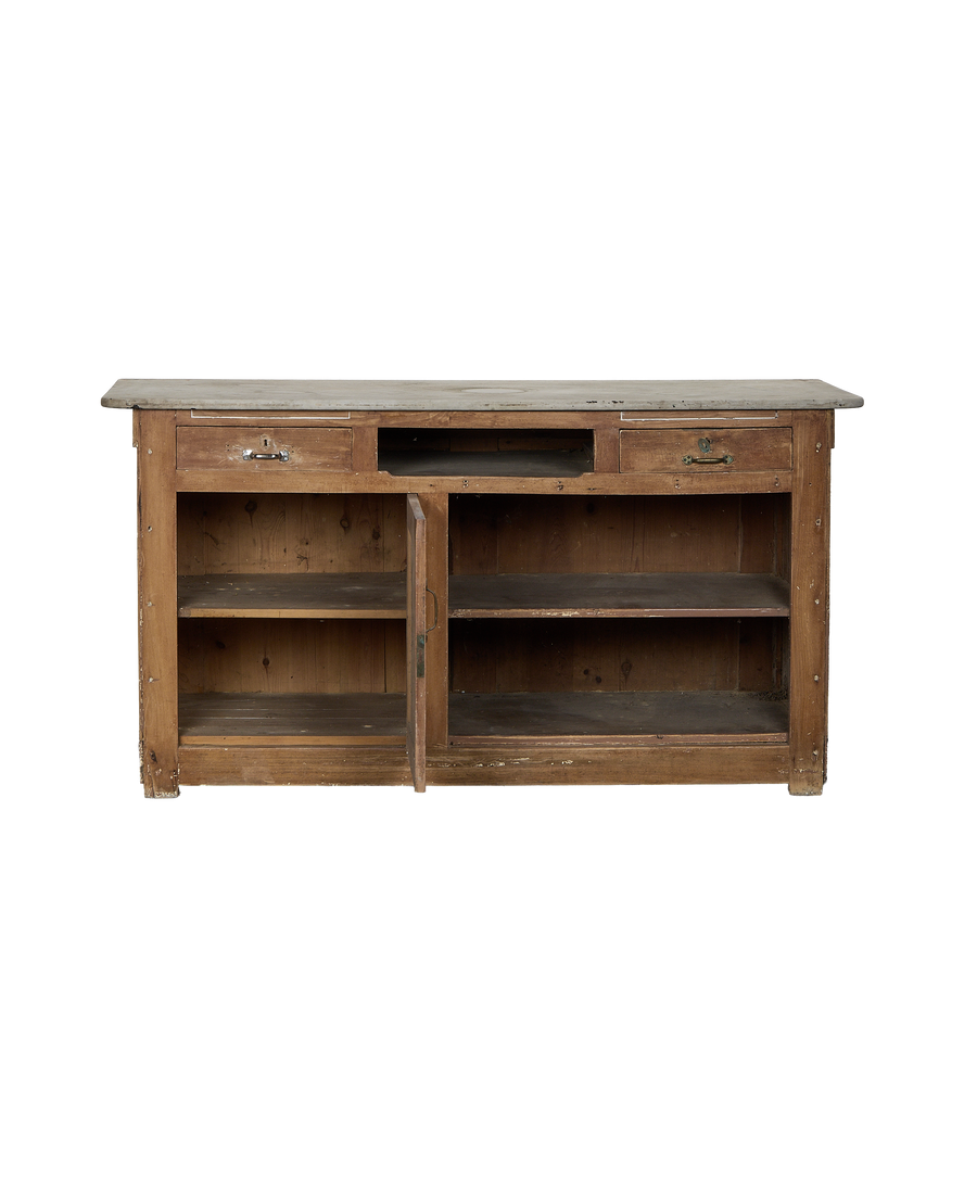 Vintage French oak bakery counter with open cabinet doors revealing interior shelves.