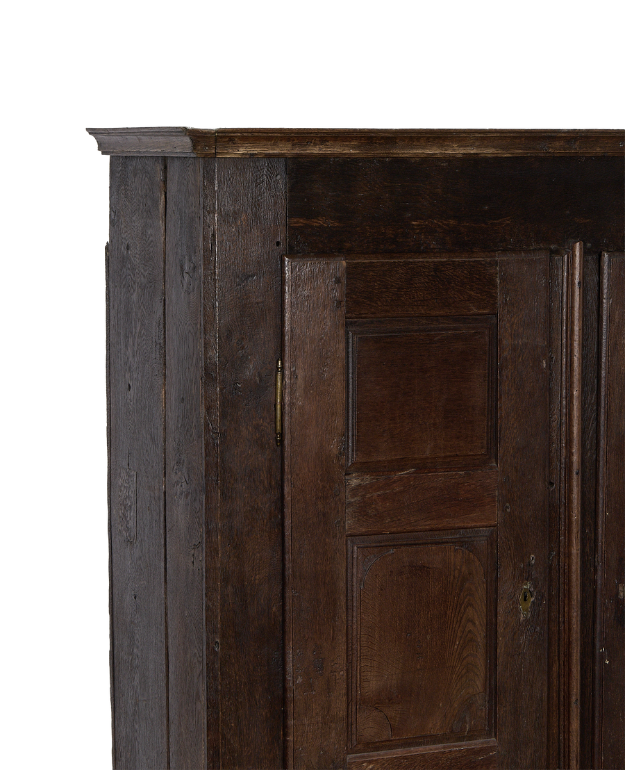 Corner view of the 1850s vintage French oak cabinet, showing brass hinge and lock.