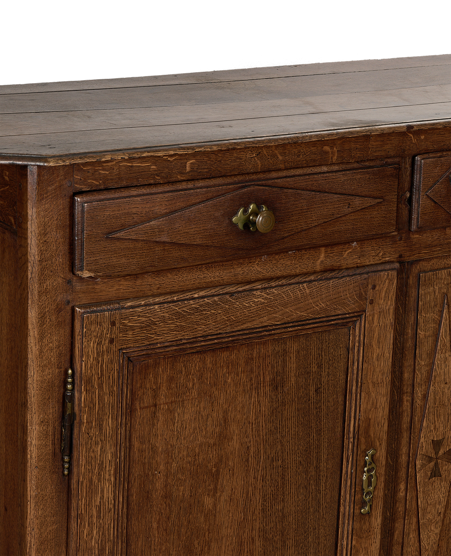 Close-up of vintage French oak dresser showing drawer with brass pull detail.