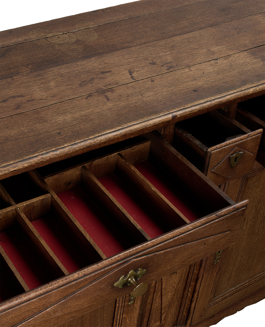 Vintage French oak dresser with open drawers showing red velvet lining and dividers.
